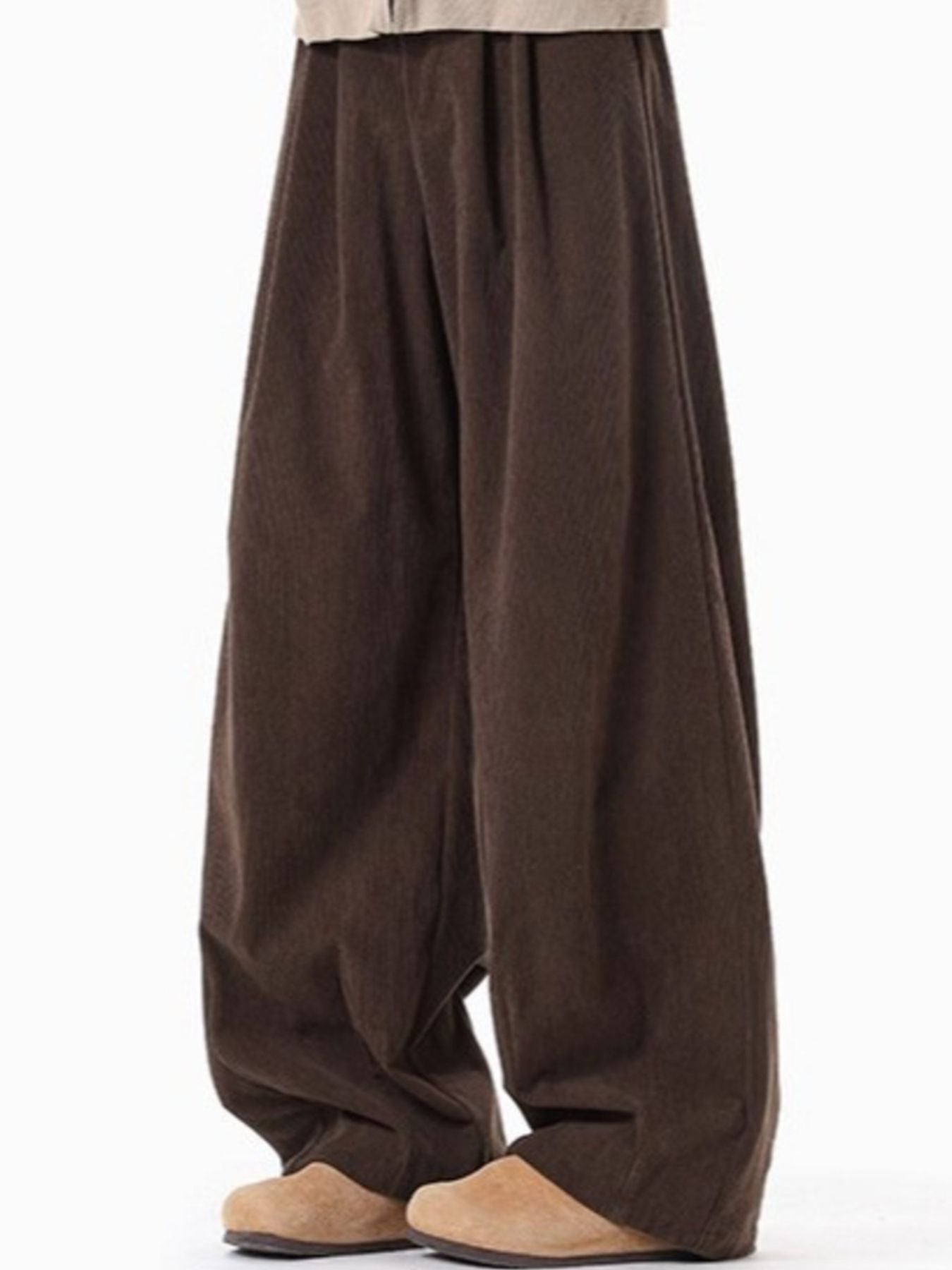 Brown pleated wide leg trousers with a textured fabric detail.