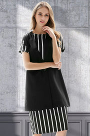 Black sleeveless vest with single button and striped cap sleeves, styled over a striped dress.