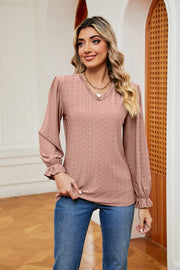 Dusty pink perforated sleeve blouse with ruffle cuffs and V-neckline.