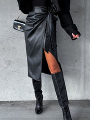 Black faux leather wrap midi skirt with asymmetric hem and thigh-high slit.