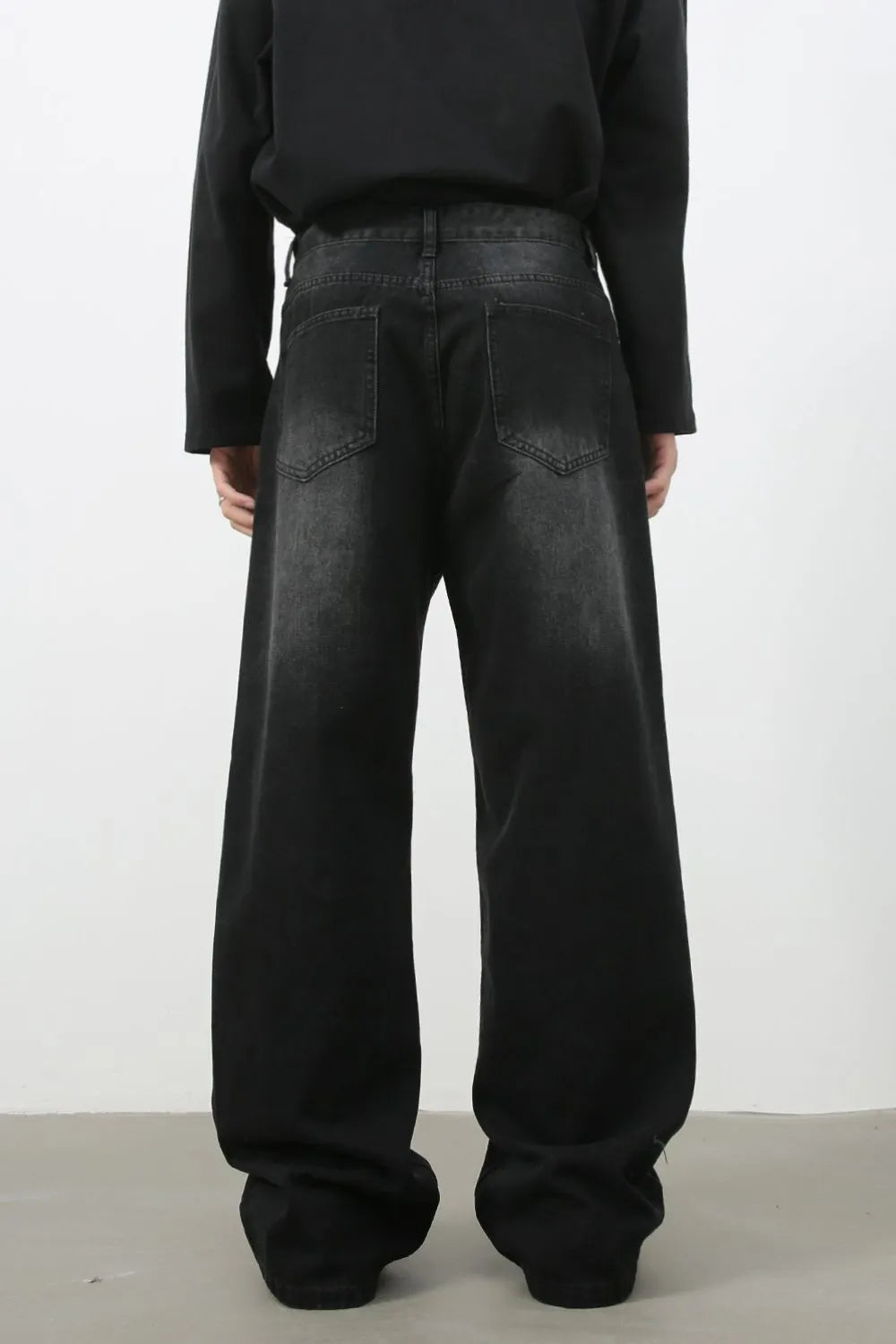 Faded black denim palazzo jeans with a wide leg and cat's whisker detail.
