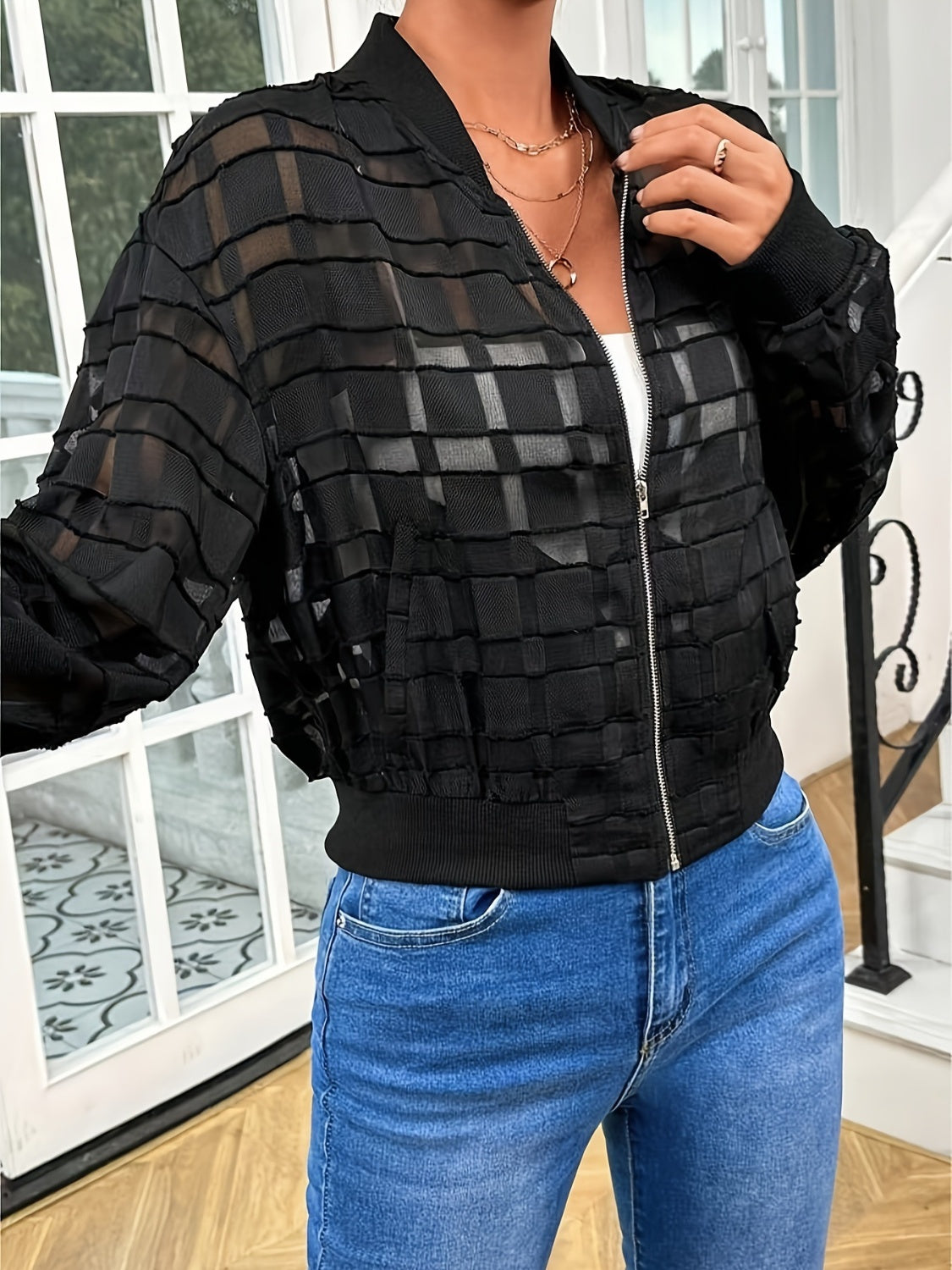 Black bomber jacket with textured gridwork pattern and ribbed cuffs and hem.