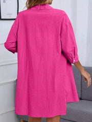 Hot pink collared button-down shirt with cuffed sleeves and side slits.
