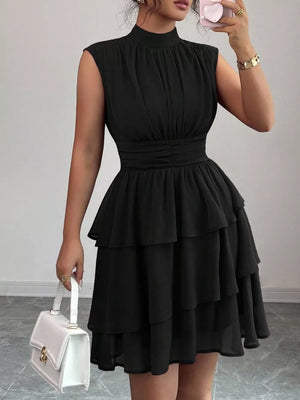 Black sleeveless ruffle tiered dress with ruched bodice and mock neck.