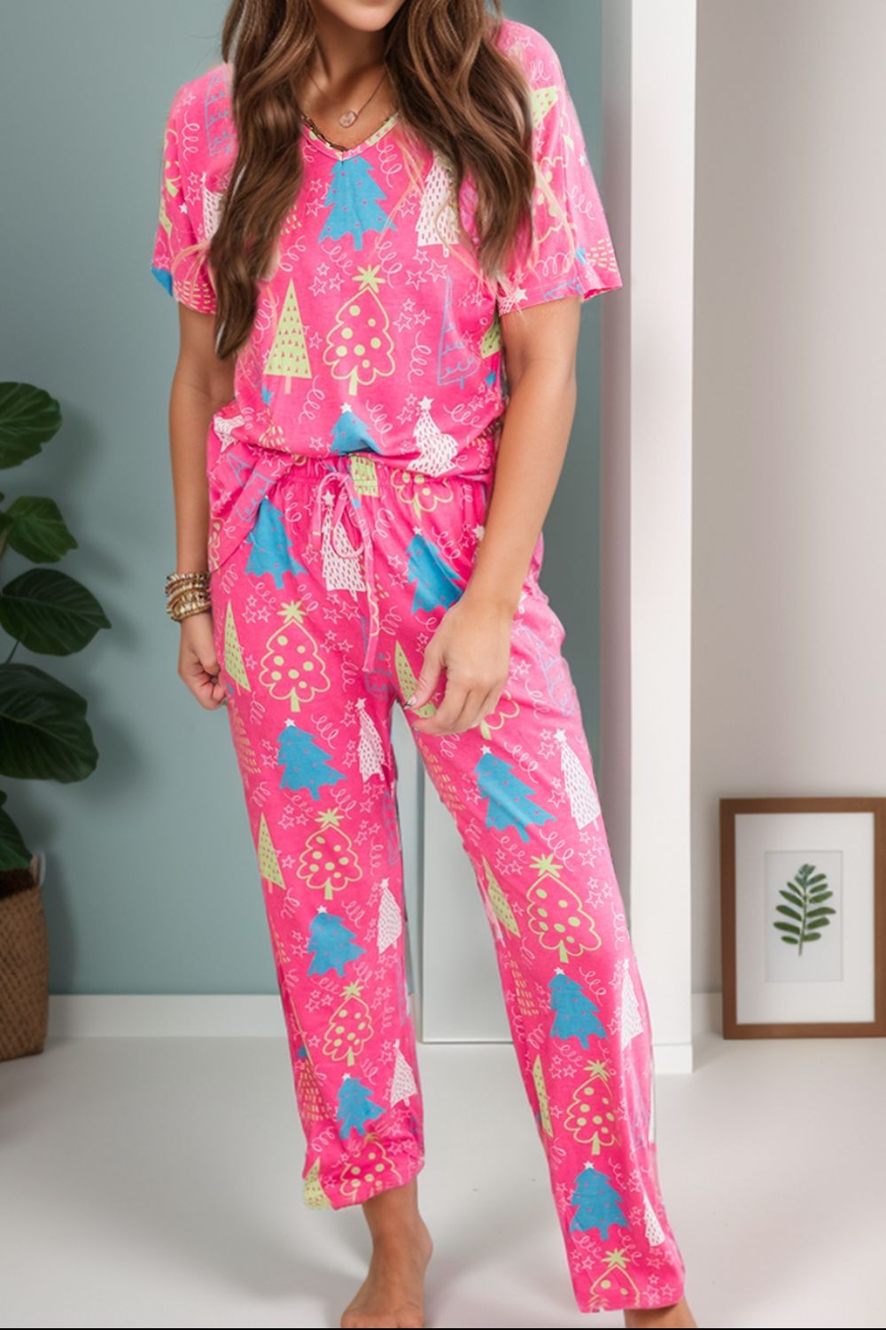 Hot pink lounge set with Christmas tree print, V-neck top and drawstring pants.