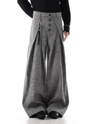 Oversized grey pleated wide-leg men's trousers with decorative chain detail.