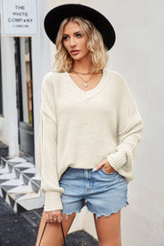 Oversized cream knit v-neck sweater with slouchy fit and ribbed cuffs.