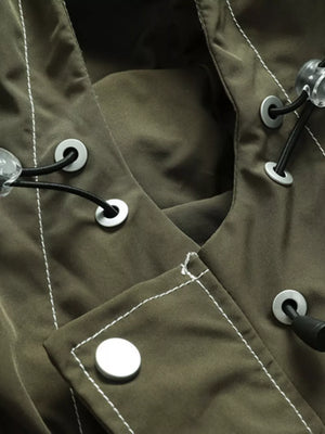 Green hooded jacket detail with white contrast stitching, drawstring toggles, and snap buttons.