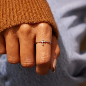 Delicate diamond cross ring in silver with small sparkling stones.