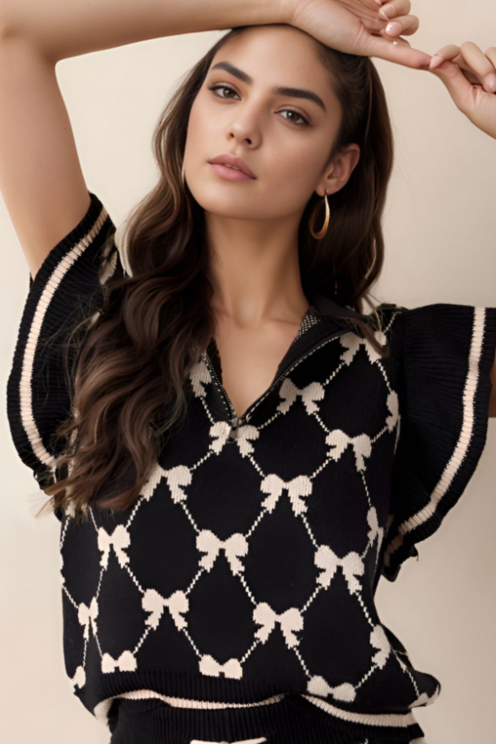 Black knit zip vest with diamond bow pattern, collared neckline, and striped trim.