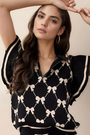 Black knit zip vest with diamond bow pattern, collared neckline, and striped trim.