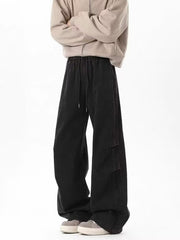 Men's black drawstring cargo pants with wide leg and utility pockets.