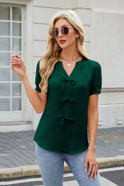 Dark green textured V-neck blouse with three bow details down the front.
