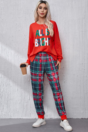 Red loungewear set with "All Is Bright" graphic tee and plaid pants.