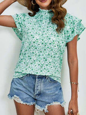 Light green floral blouse with ruffled neckline and flutter sleeves.