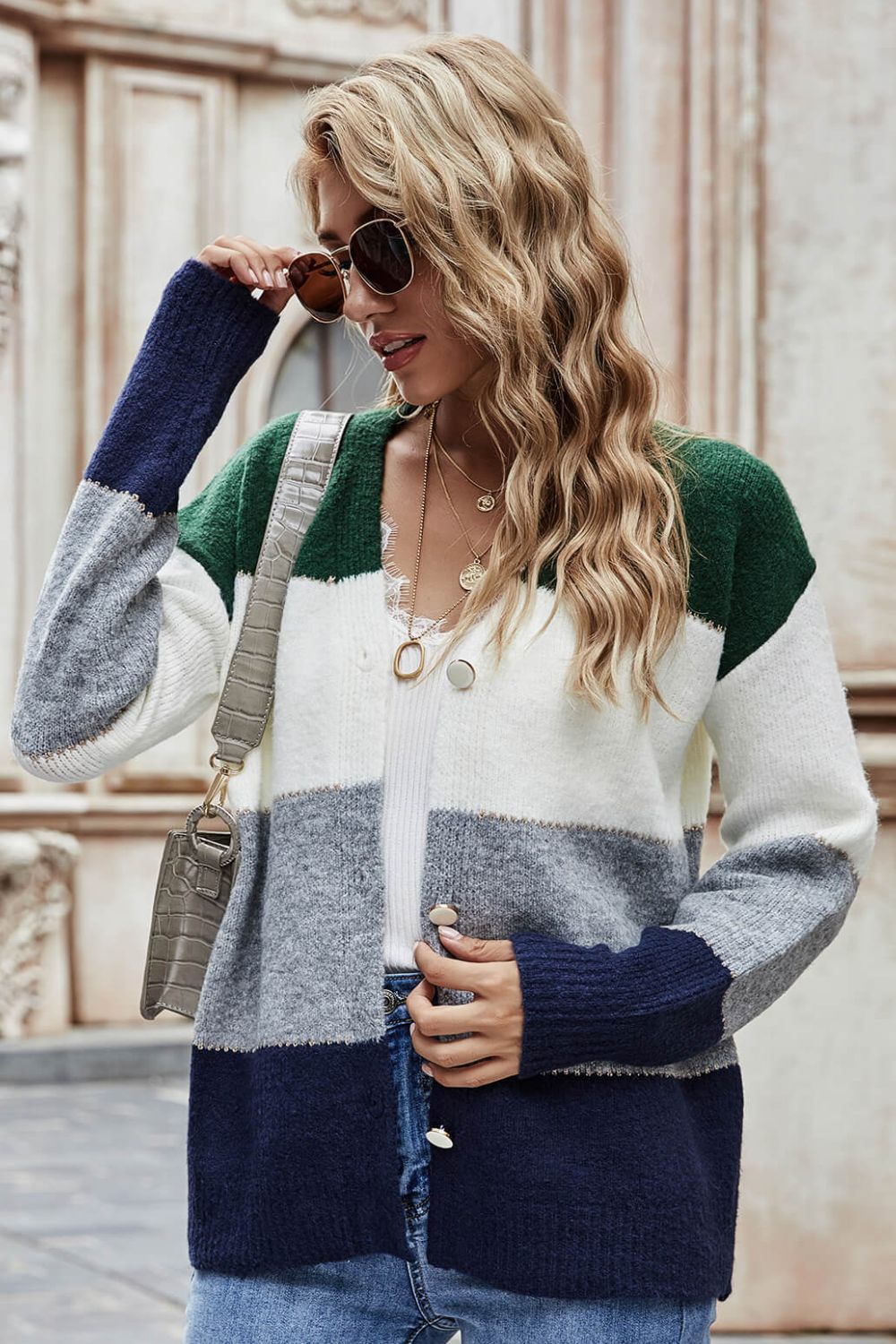 Colorblock acrylic cardigan with metallic trim in green, white, grey, and dark blue.