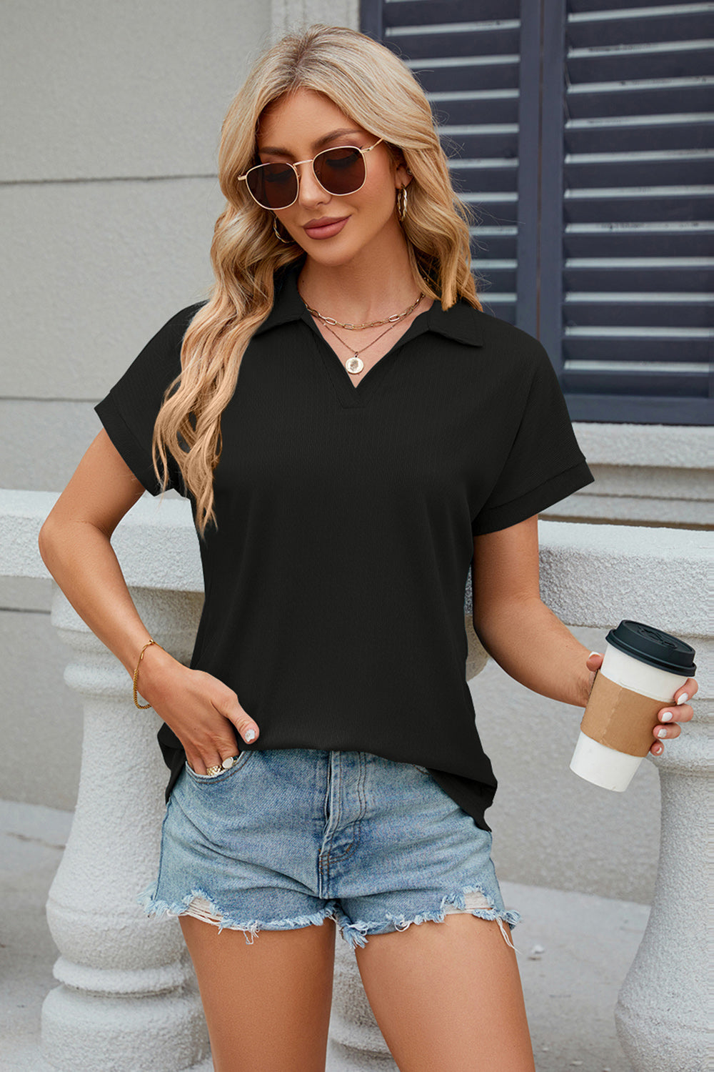 Black textured polo top with V-neck and cuffed short sleeves