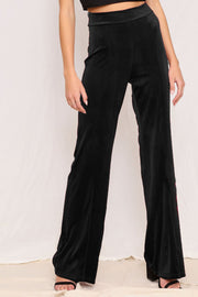 Plush velvet wide-leg trousers in black with red side stripe detail.