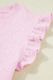 Blush pink loungewear set with embossed bow pattern and ruffle sleeves.