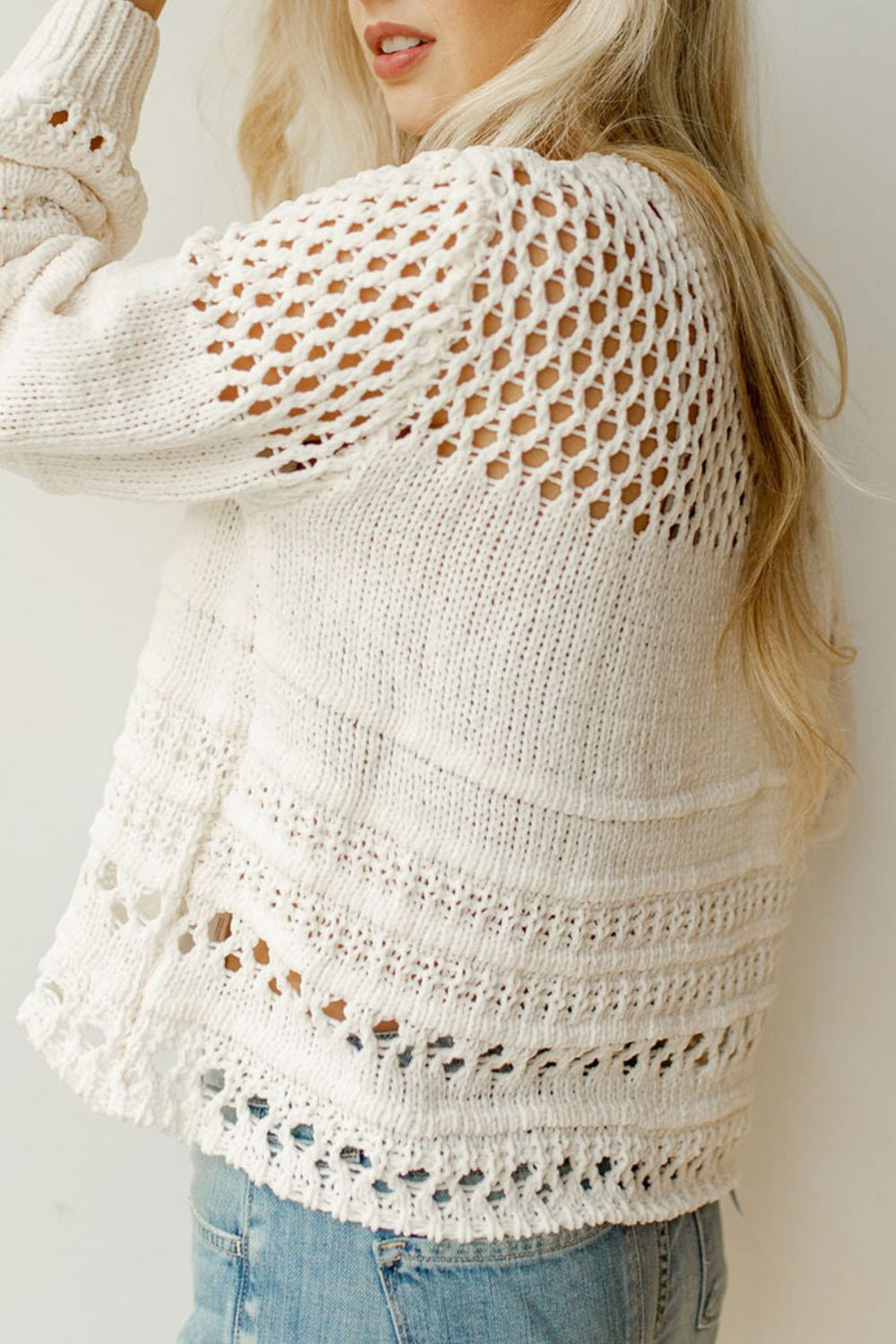 Ivory openwork knit pullover sweater with balloon sleeves and textured details.