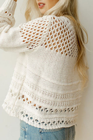 Ivory openwork knit pullover sweater with balloon sleeves and textured details.