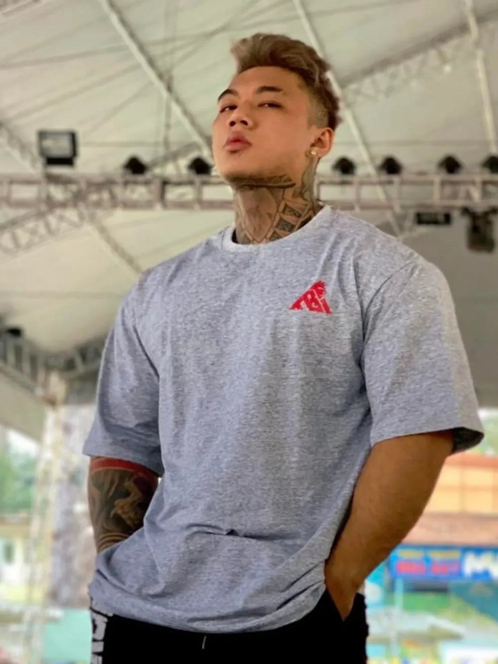 Gray oversized t-shirt with red graphic detail on chest and red band on sleeve.