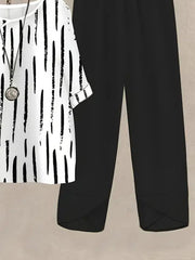 White half sleeve top with black brushstroke print and black pants.
