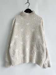 Textured turtleneck sweater in cream with a subtle heart motif and acrylic blend.