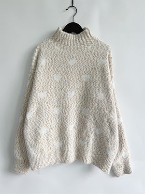 Textured turtleneck sweater in cream with a subtle heart motif and acrylic blend.