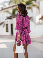 Tropical tiered mini dress in fuchsia pink with a belted waist and ruffled hem.