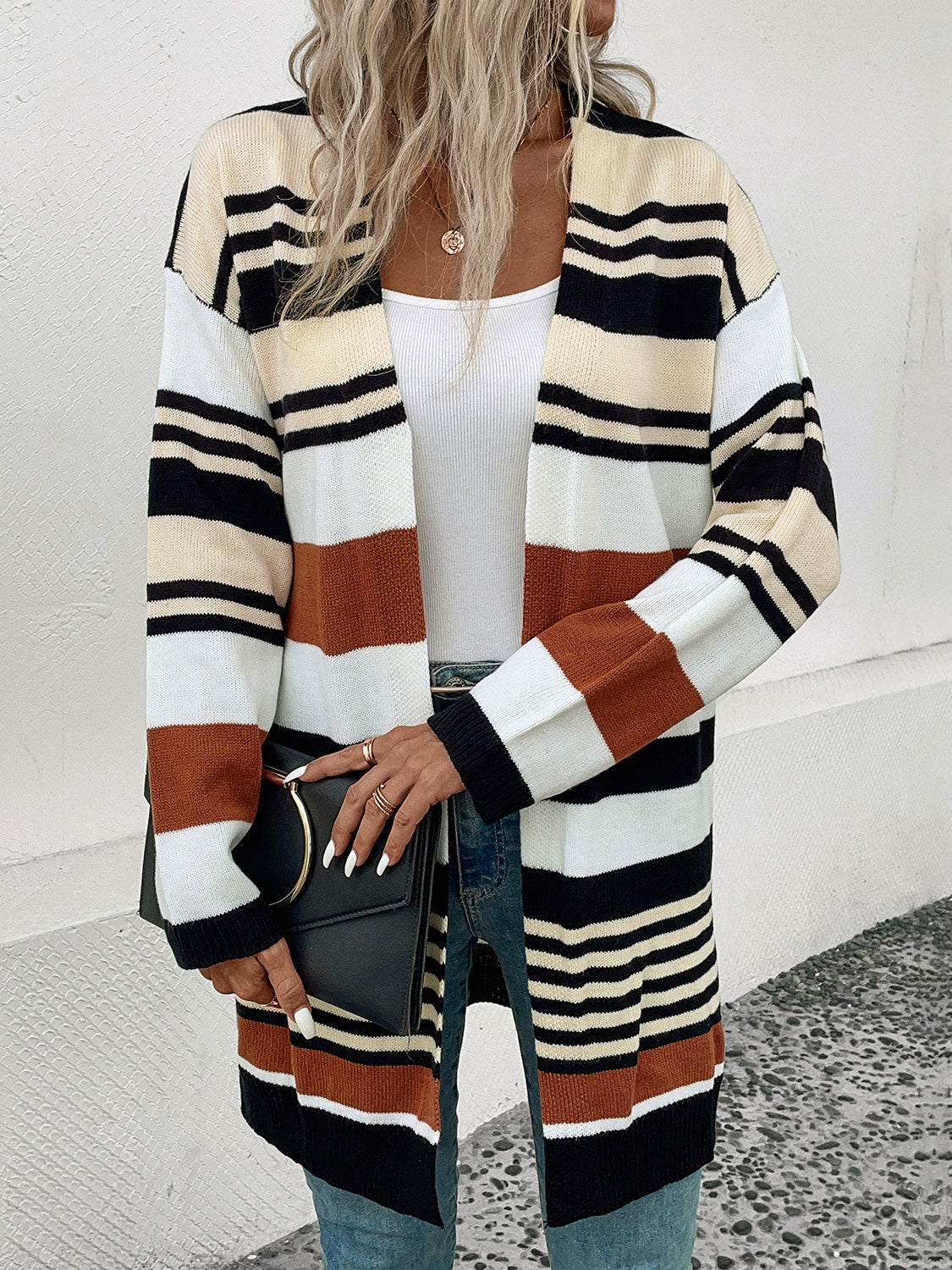 Bold stripe knit duster cardigan with burnt orange, black, white, and cream stripes.