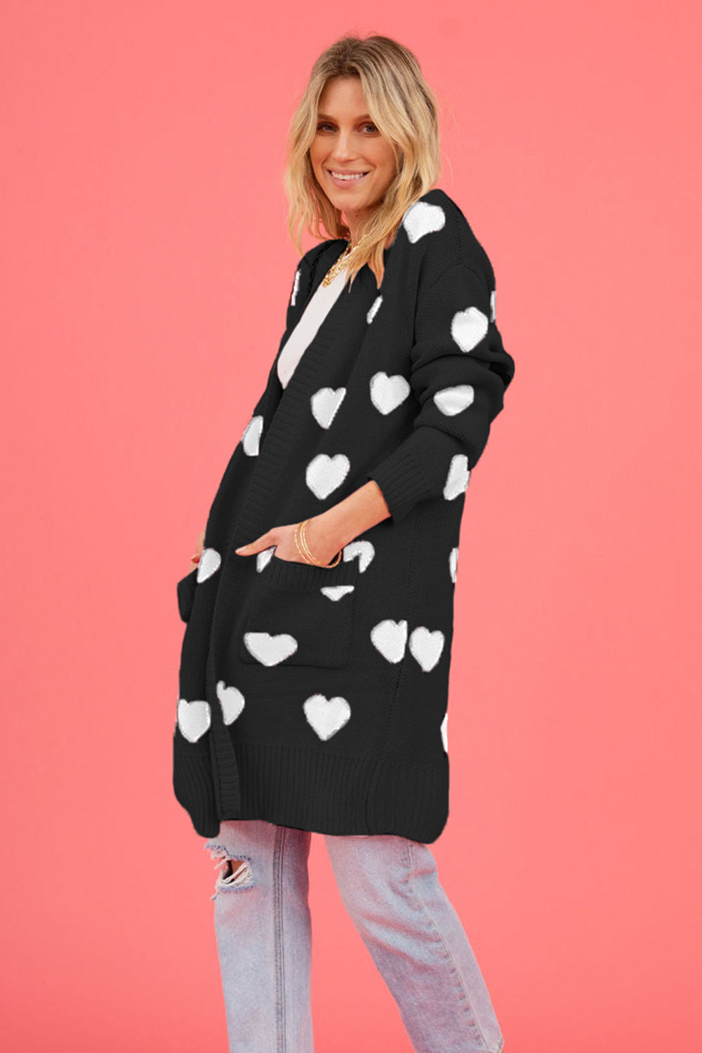 Black acrylic longline cardigan with white heart motif and pockets.