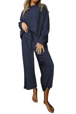 Dark blue loungewear set with textured pattern, crew neck top and wide leg pants.