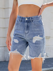 Medium wash denim bermuda shorts with distressed rips and frayed hem