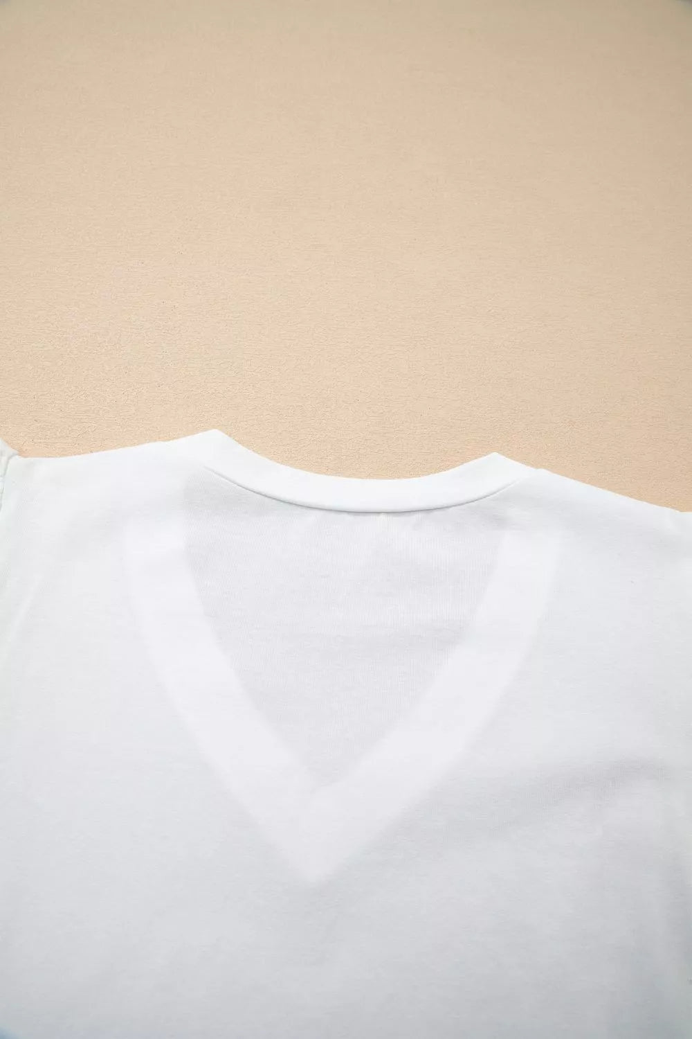 White cotton maternity t-shirt with V-neckline and flutter sleeves, delicate eyelet detail