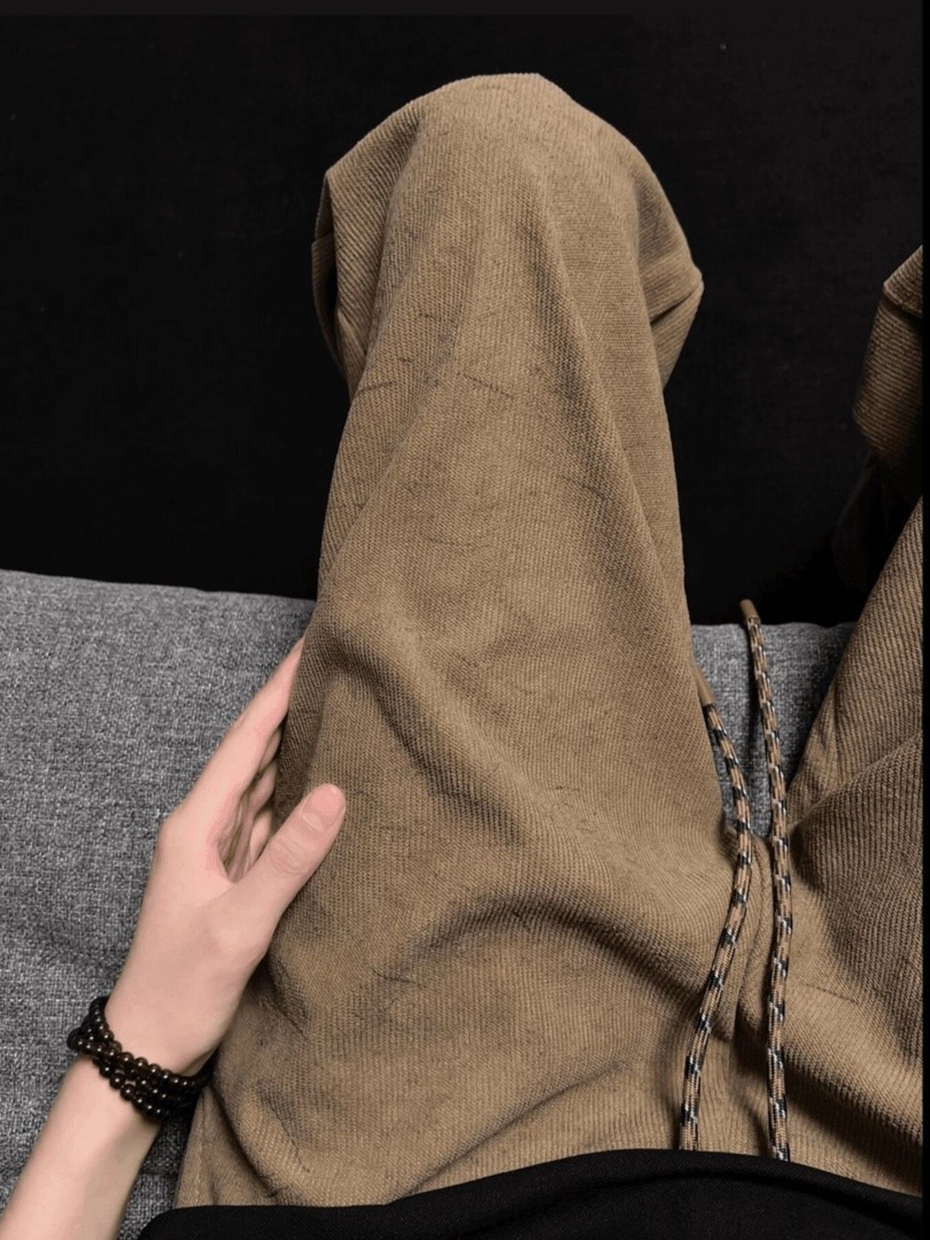 Men's beige corduroy drawstring trousers with a relaxed fit.