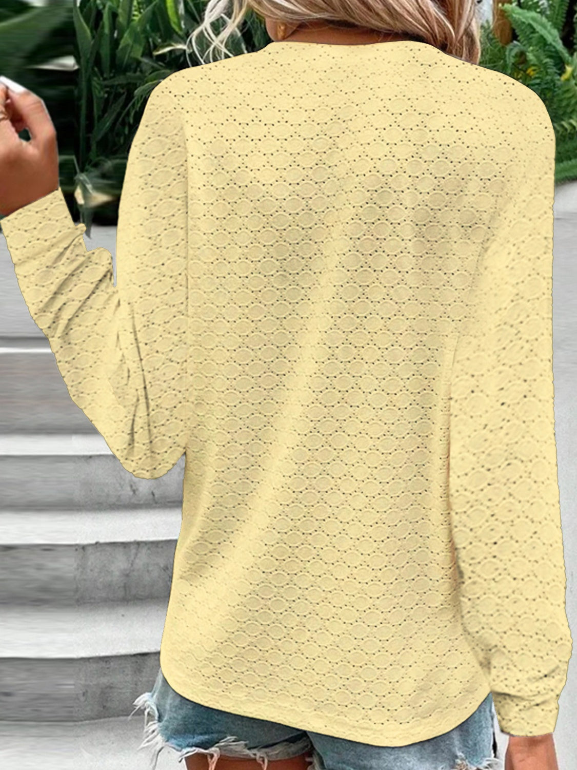 Yellow lace-effect henley blouse with button detail and long sleeves.