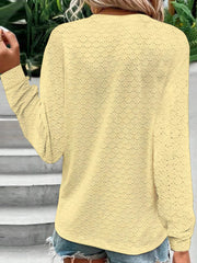 Yellow lace-effect henley blouse with button detail and long sleeves.