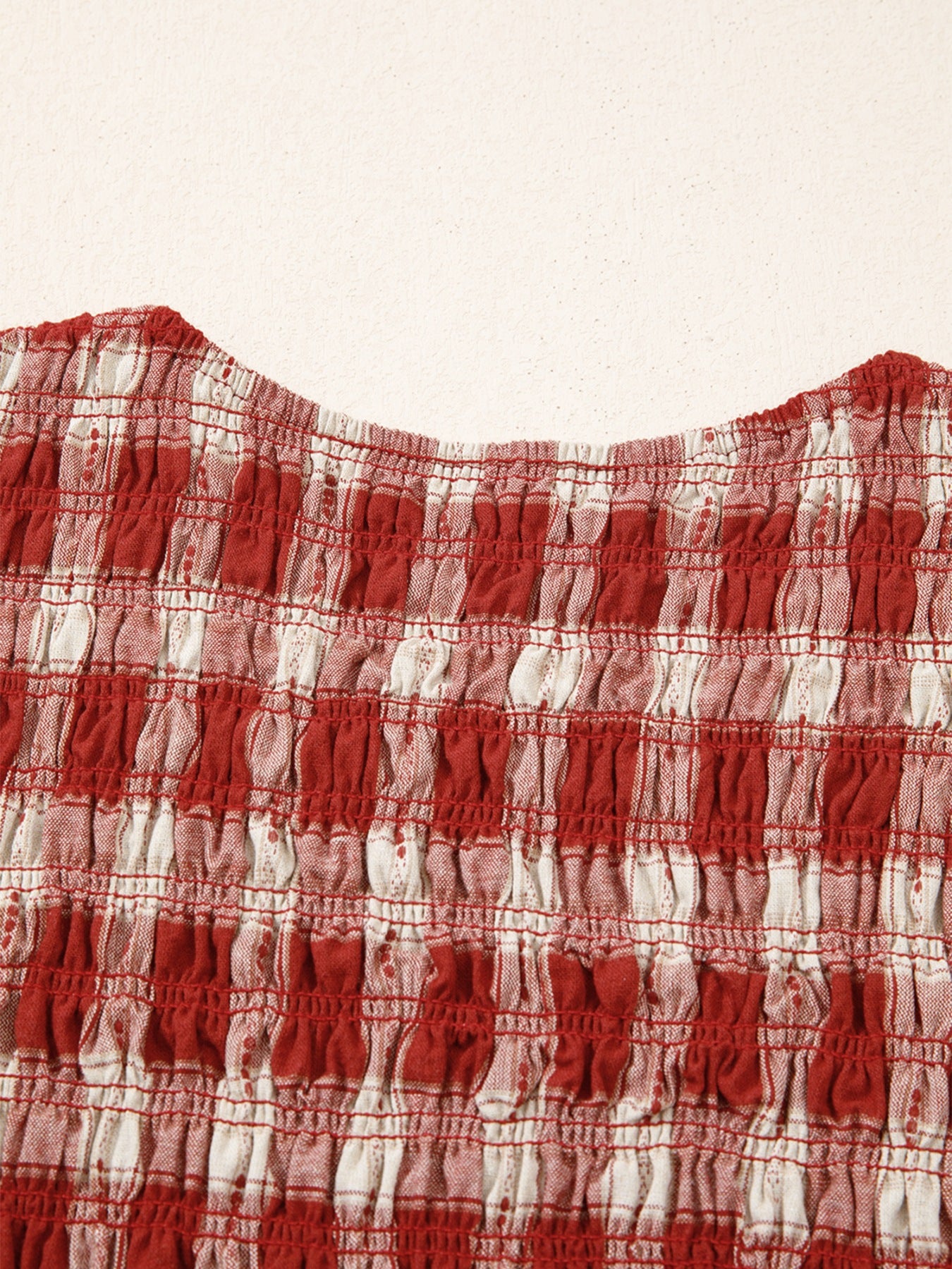 Red and white gingham smocked mini dress with puff sleeves.