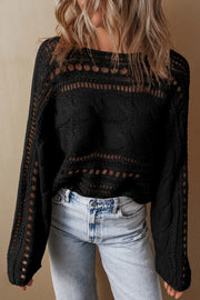 Black cable knit sweater with cutout details and open knit sleeves.