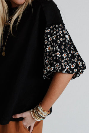 Black t-shirt with daisy print puff sleeves and a round neckline