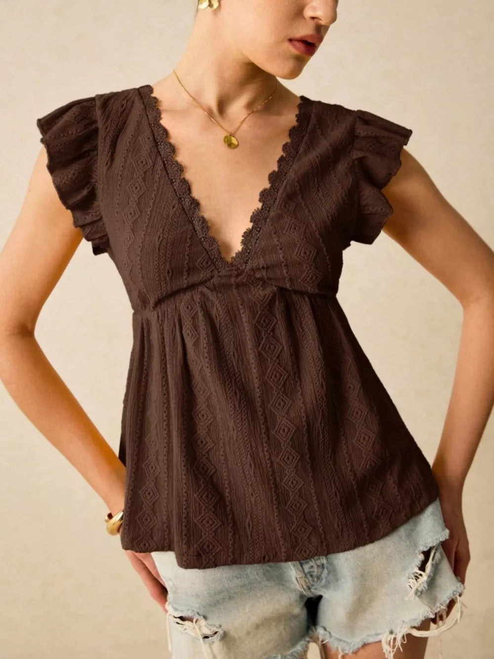 Brown eyelet blouse with lace trim and ruffle sleeves.