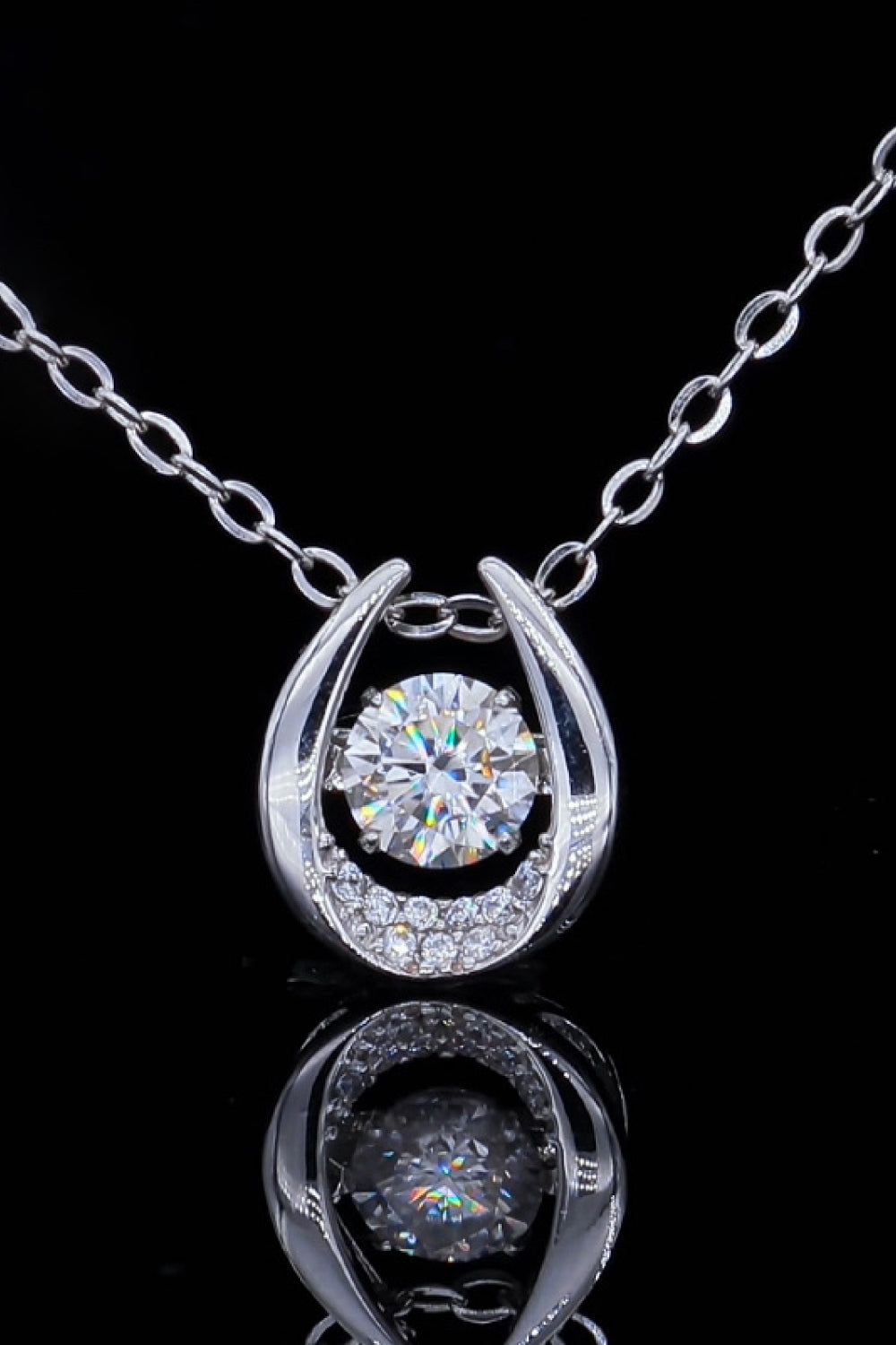 Silver orbital diamond halo necklace with a central stone and pave accents.