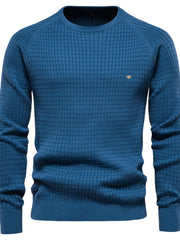 Textured grid crewneck sweater in peacock blue with raglan sleeves and a small logo detail.