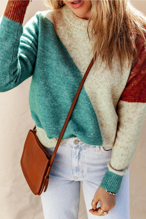 Geometric colorblock knit sweater in cream, teal, and rust with a crew neck.