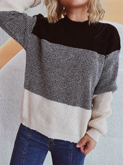 Colorblock knit pullover sweater with textured fabric in black, grey, and cream.