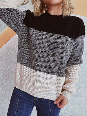 Colorblock knit pullover sweater with textured fabric in black, grey, and cream.