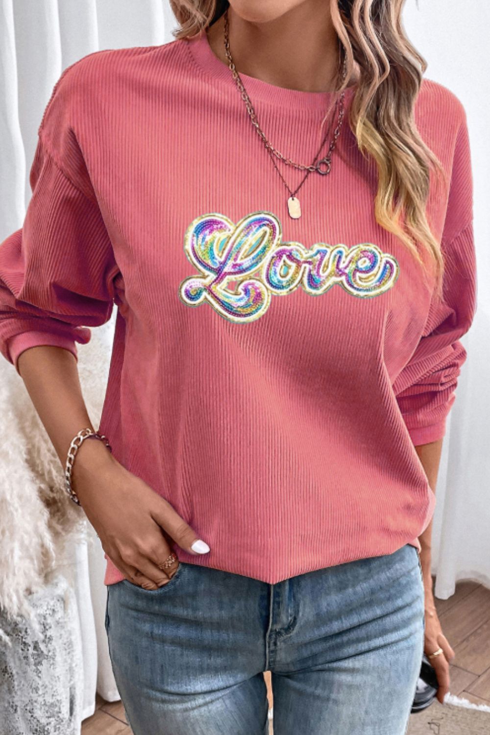 Burnt coral corduroy sweatshirt with a sequined "Love" appliqué and crew neck.