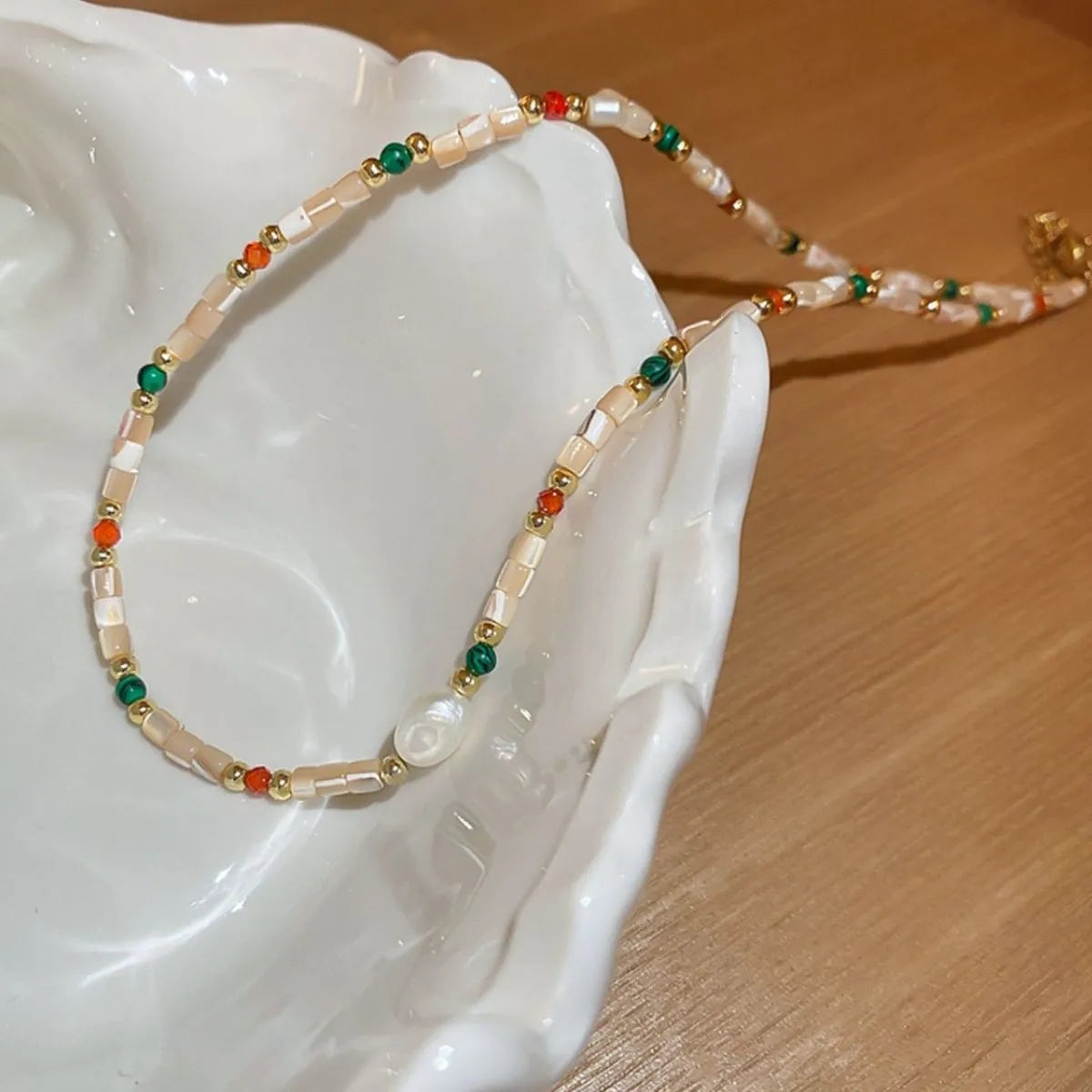 Multi-strand gemstone collar necklace with pearl, beads, and gold accents.