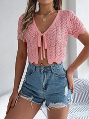 Pale blush crochet tie-front top with scalloped edges and short sleeves.